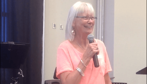 Adult lady holding a microphone and smiling