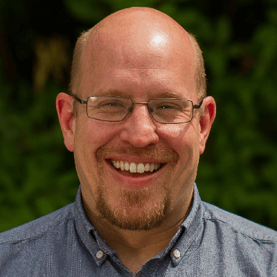 Bald middle-aged man with glasses smiling
